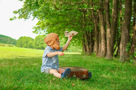 Baby boy by the plane plays on nature in the park. Boy on vacation pilot.の写真素材