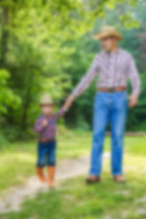happy child with cowboy parent in nature in the fieldの写真素材