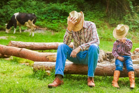 happy child with cowboy parent in nature in the fieldの写真素材