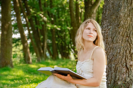 happy girl on the nature of reading a book in the parkの写真素材