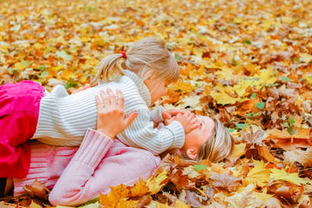 Happy parents with baby on nature in autumn parkの写真素材