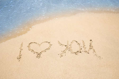 beautiful drawing on the sand near the sea shore backgroundの写真素材