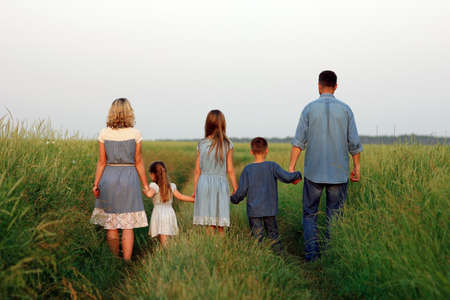 Happy family walk along the road in the park on nature background