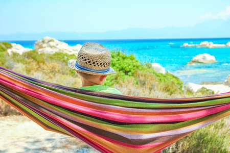 happy child by the sea on hammock in greece background