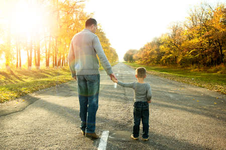 happy father and son walk in nature autumnの写真素材