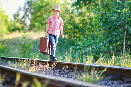 boy cowboy with suitcase and railroad western travel conceptの写真素材