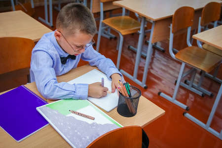 Happy child at school desk at school after schoolの写真素材