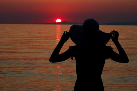 girls in hat silhouette by the sea on summer on Greeceの写真素材