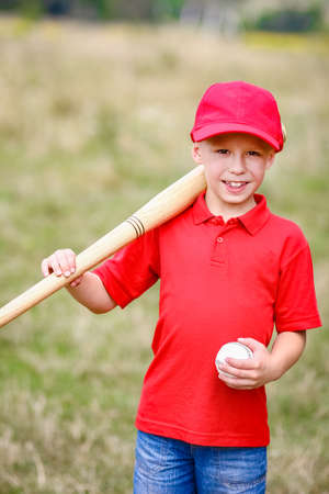 Happy child with baseball bat on nature concept in park