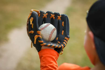 Happy child with baseball ball on nature concept in parkの写真素材