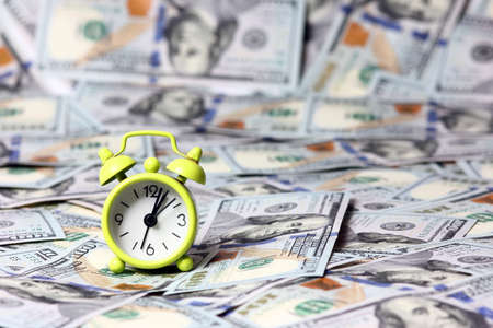 alarm clock and a lot of dollars time money concept