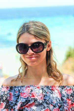 Happy girl in glasses near the sea in nature journey