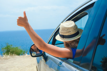 happy girl from car at sea greece backgroundの写真素材