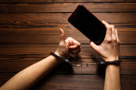 phone with hands addiction on a wooden backgroundの写真素材