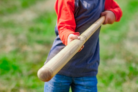 Happy child with baseball bat on nature concept in park