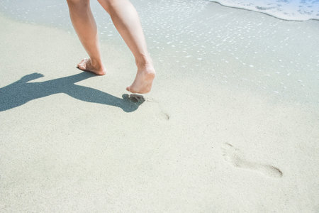 Feet and footprints by the seashore in nature travel vacation backgroundの写真素材