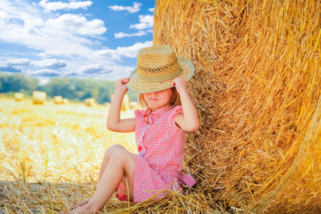 happy child on a field with bales harvest in autumn