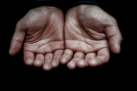 Hands of a begging poor man on the street bumの写真素材