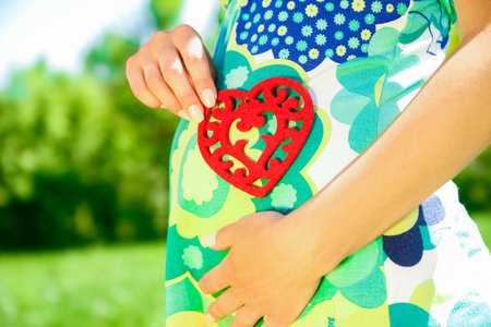 Happy pregnant woman on the nature in the parkの写真素材