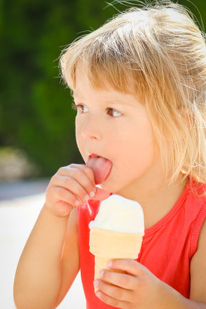 Happy child eating ice cream on the nature of the parkの写真素材