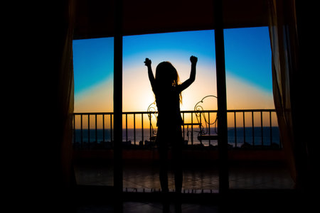 Beautiful silhouette of happy children on the sea backgroundの写真素材