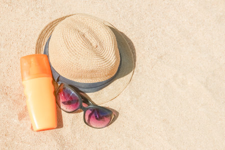 Stylish beautiful hat with cream on the seashore background