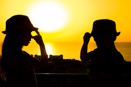 Happy child in hat silhouette on sea backgroundの写真素材