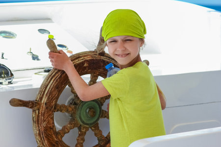 Happy child at the helm of the ship in the sea backgroundの写真素材