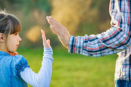 beautiful hands of parent and child outdoors in the parkの写真素材