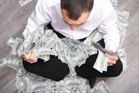 Happy guy with money in his hands for the development of shopping business and a great tripの写真素材