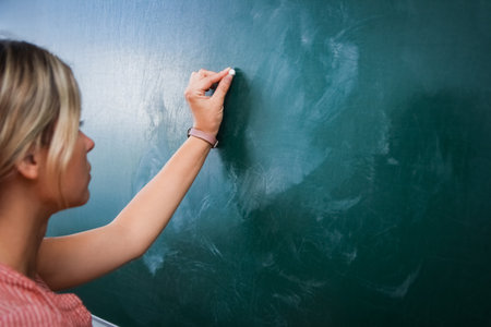 Happy teacher at the blackboard in the classroom room back to classの写真素材