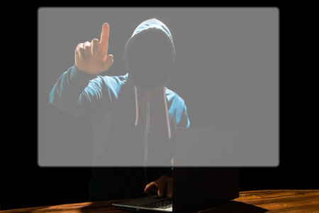 Hacker with laptop sits at a table and abstract binary code. Business life threat virtual programs.の写真素材