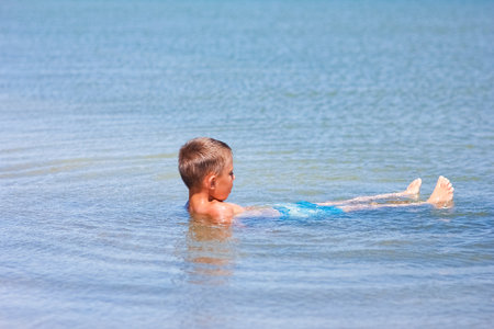 Happy child playing in the sea swim in natureの写真素材