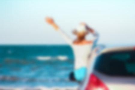 Happy girl in the car by the sea in nature on vacation travelの写真素材