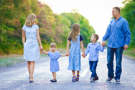 Happy family walking along the road in the park on nature travelの写真素材