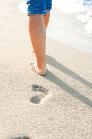 beautiful traces with feet near the sea on nature backgroundの写真素材
