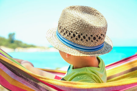 happy child by the sea on hammock in greece backgroundの写真素材