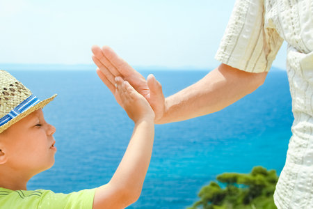 hands of happy parents and children at sea in travel background in greeceの写真素材