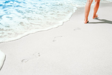 Feet and footprints by the seashore in nature travel vacation backgroundの写真素材