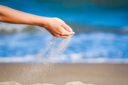 Beautiful hand throws sand relax on the sea weekend travelの写真素材