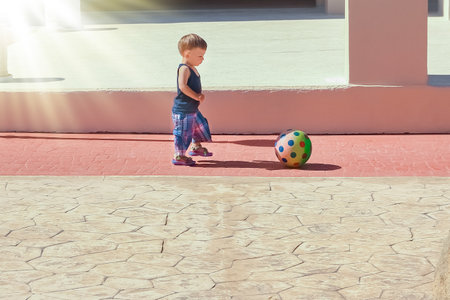 happy child with a ball playing on the nature in the parkの写真素材
