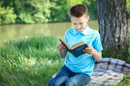 child boy  read holy bible in parkの写真素材