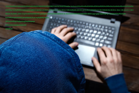 Hacker with laptop sits at a table and abstract binary code. Business life threat virtual programs.