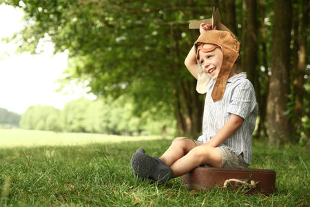 Baby boy by the plane plays on nature in the park. Boy on vacation pilot.の写真素材