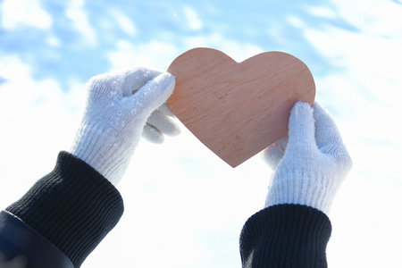 Heart in the hands of a girl against the sky Valentine's day in a park in natureの写真素材