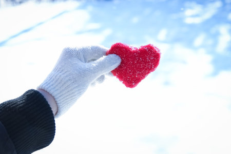 Heart in the hands of a girl against the sky Valentine's day in a park in nature