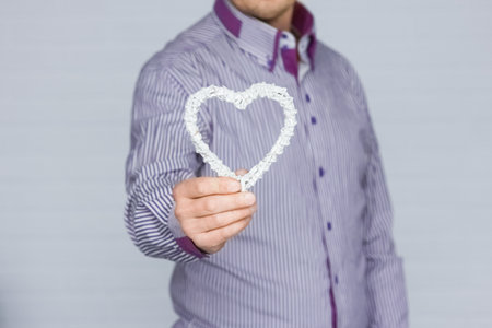 Heart in human hands on white brick backgroundの写真素材
