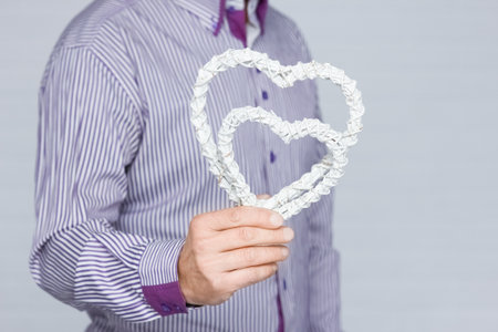 Heart in human hands on white brick backgroundの写真素材
