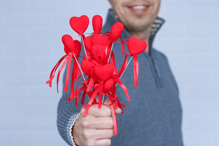 Heart in human hands on white brick backgroundの写真素材