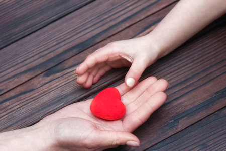 Heart in hands on valentine's day on a wooden background holidayの写真素材